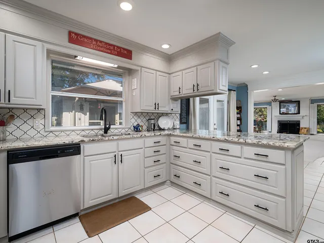 a kitchen with granite countertop white cabinets and white stainless steel appliances