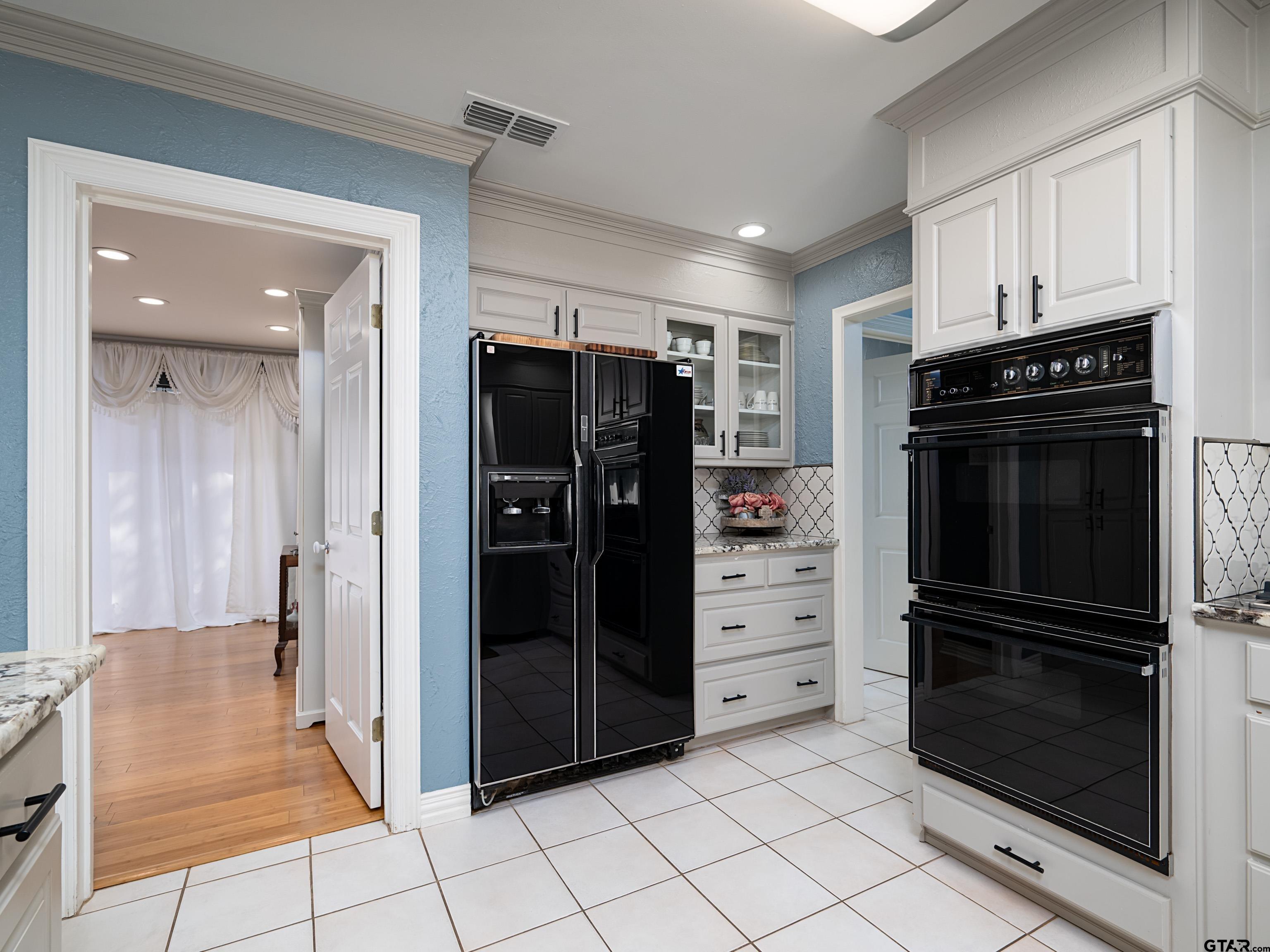8212 Cambridge Road Tyler, TX 75703 - Photo 13 of 44 a kitchen with a refrigerator and a stove