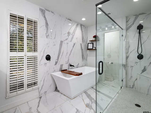 a bathroom with a tub a window and a shower