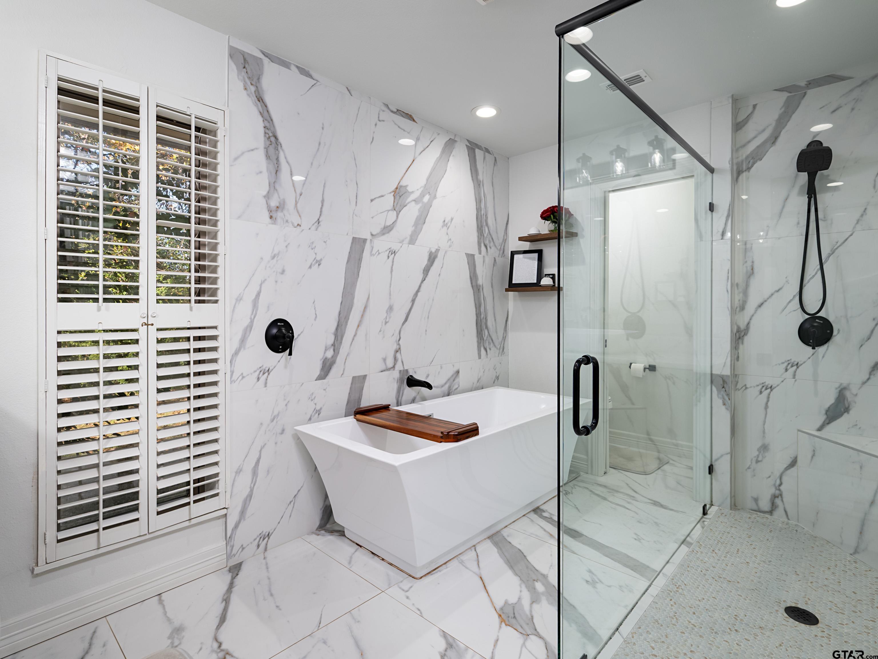 8212 Cambridge Road Tyler, TX 75703 - Photo 18 of 44 a bathroom with a tub a window and a shower