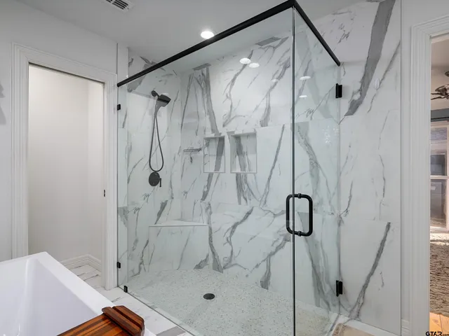 a bathroom with a shower and a glass door