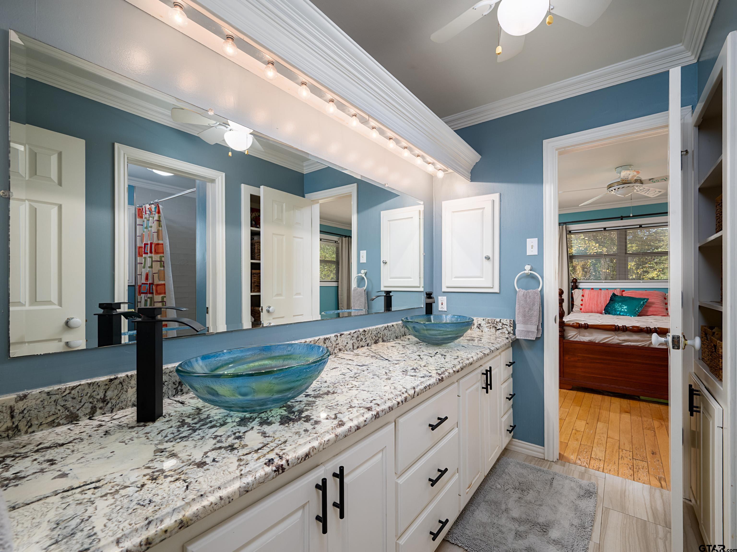 8212 Cambridge Road Tyler, TX 75703 - Photo 21 of 44 a bathroom with a granite countertop sink and a large mirror
