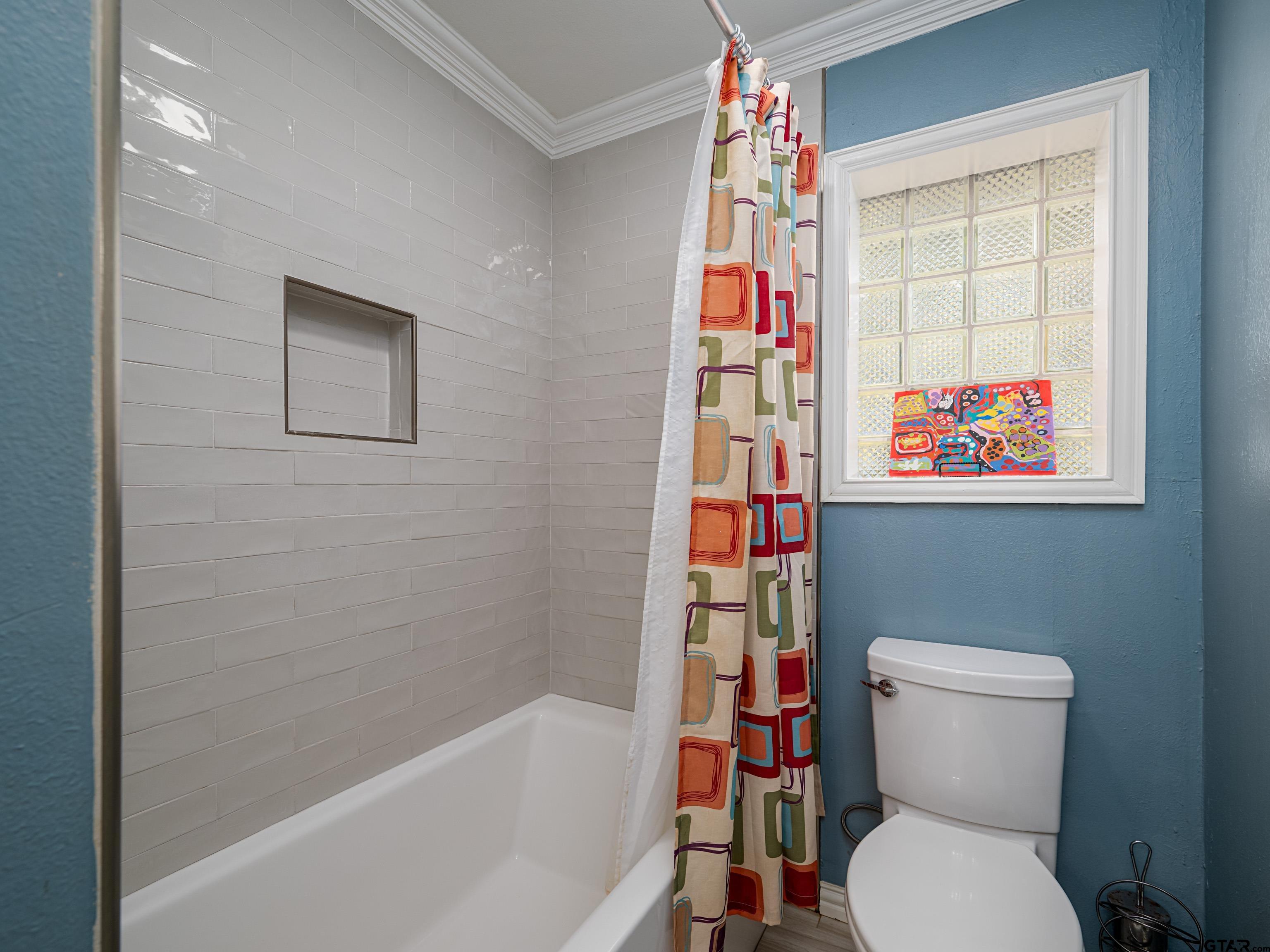 8212 Cambridge Road Tyler, TX 75703 - Photo 22 of 44 a bathroom with a toilet and a shower curtain