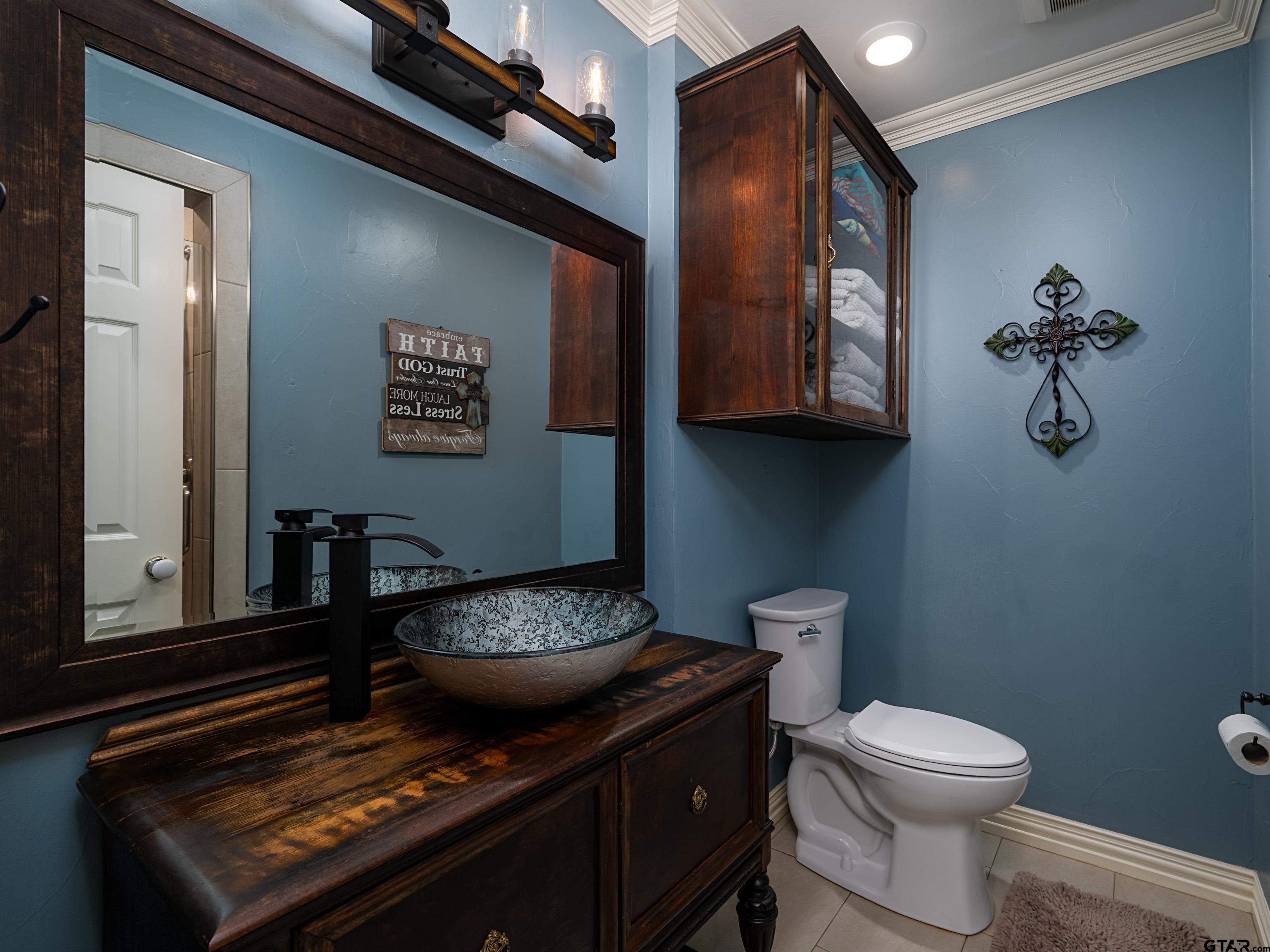 8212 Cambridge Road Tyler, TX 75703 - Photo 25 of 44 a bathroom with a toilet a sink and mirror