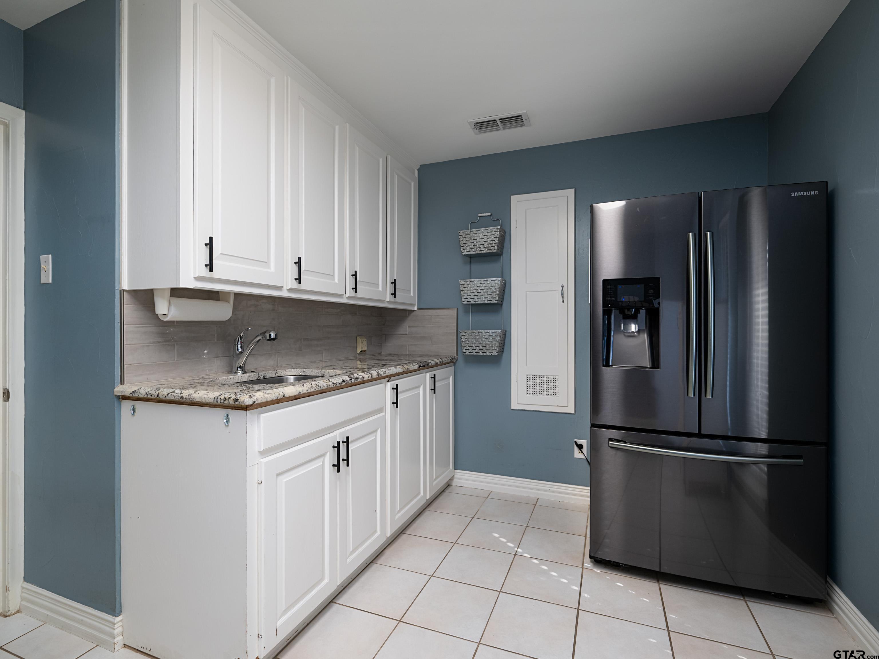 8212 Cambridge Road Tyler, TX 75703 - Photo 30 of 44 a kitchen with stainless steel appliances granite countertop a refrigerator and a stove