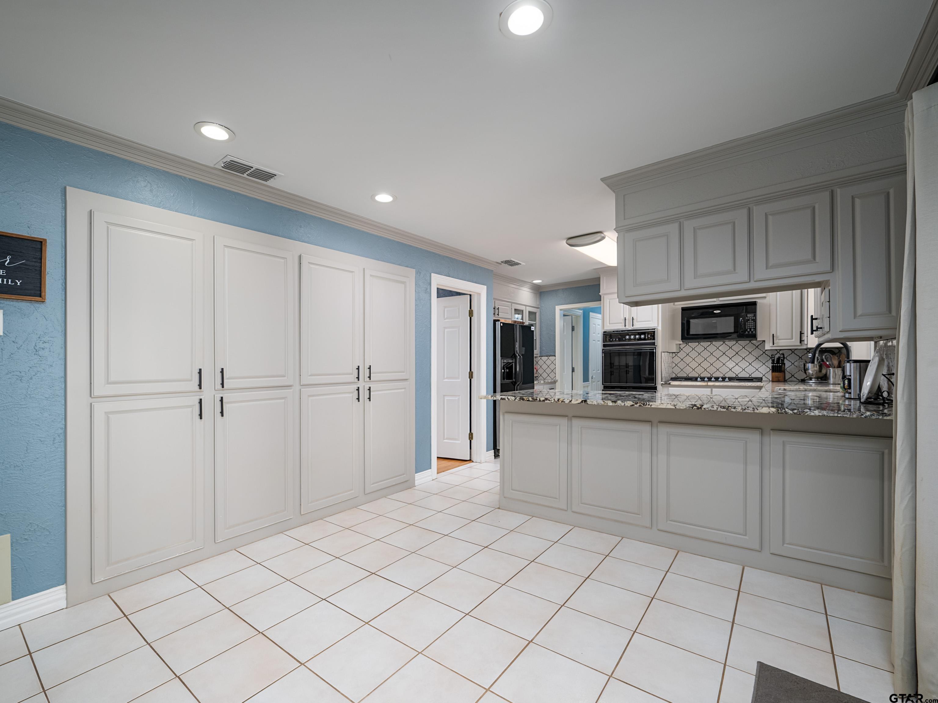 8212 Cambridge Road Tyler, TX 75703 - Photo 10 of 44 a kitchen with stainless steel appliances granite countertop a refrigerator and a sink