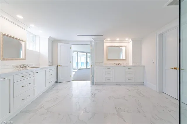 a spacious bathroom with a granite countertop sink a mirror and a bathtub