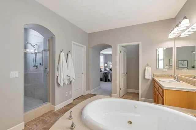 a spacious bathroom with a tub sink and mirror