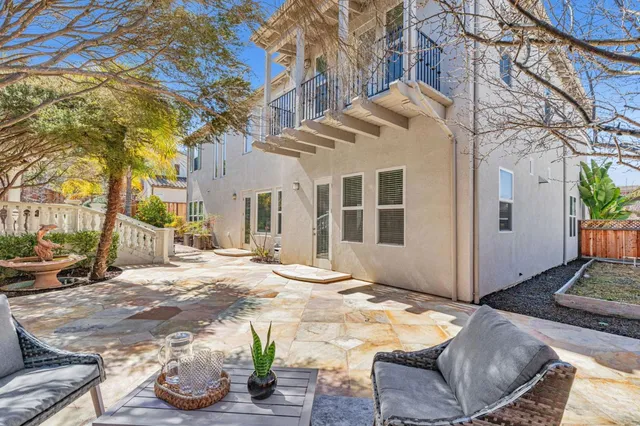 a view of a house with a yard and potted plants