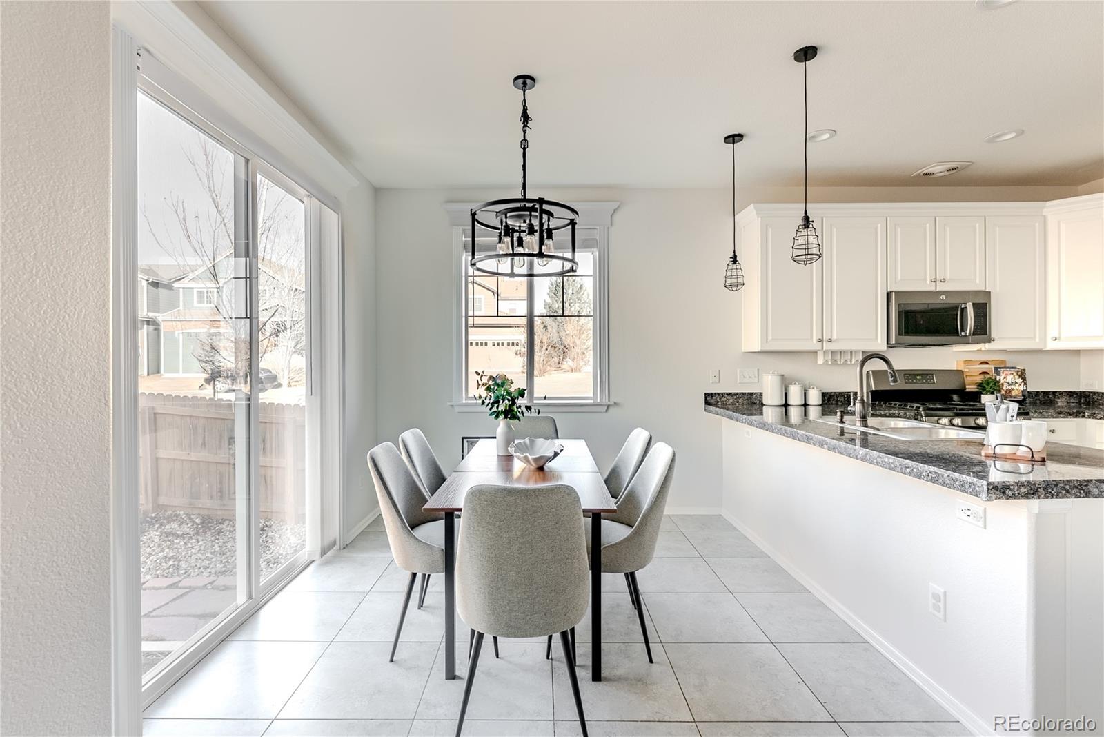 602 Mathews Way Erie, CO 80516 - Photo 12 of 50 a dining room with furniture a chandelier and window