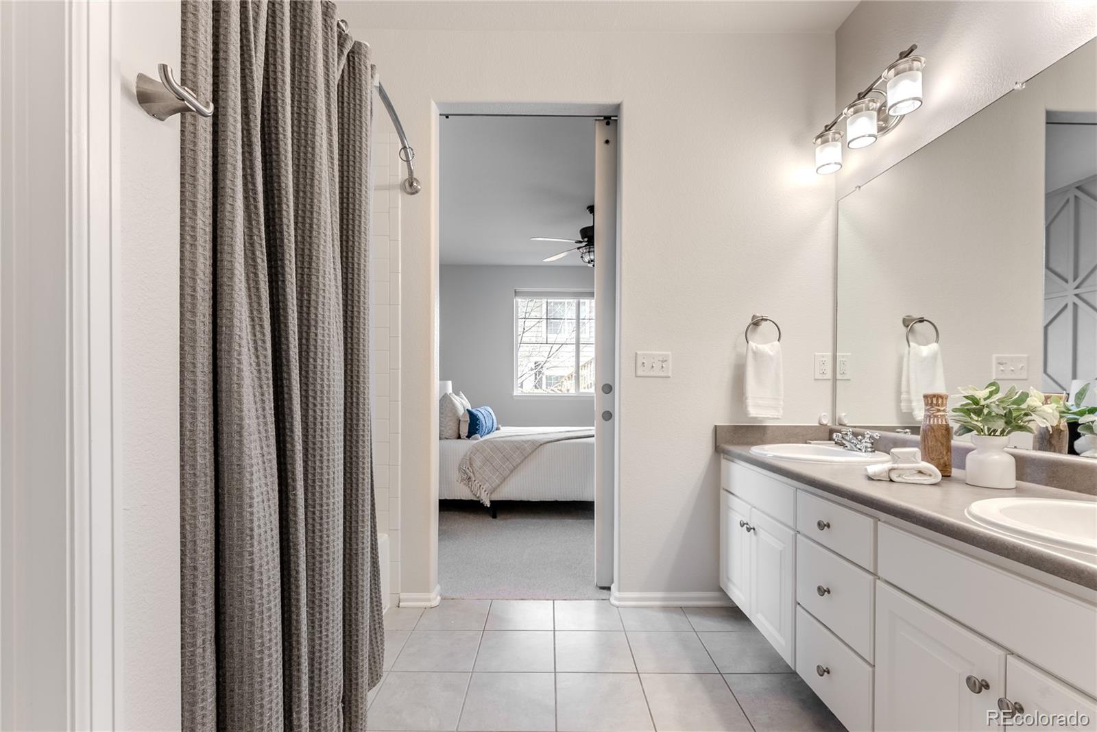 602 Mathews Way Erie, CO 80516 - Photo 21 of 50 a spacious en suite bathroom with a double sink and mirror