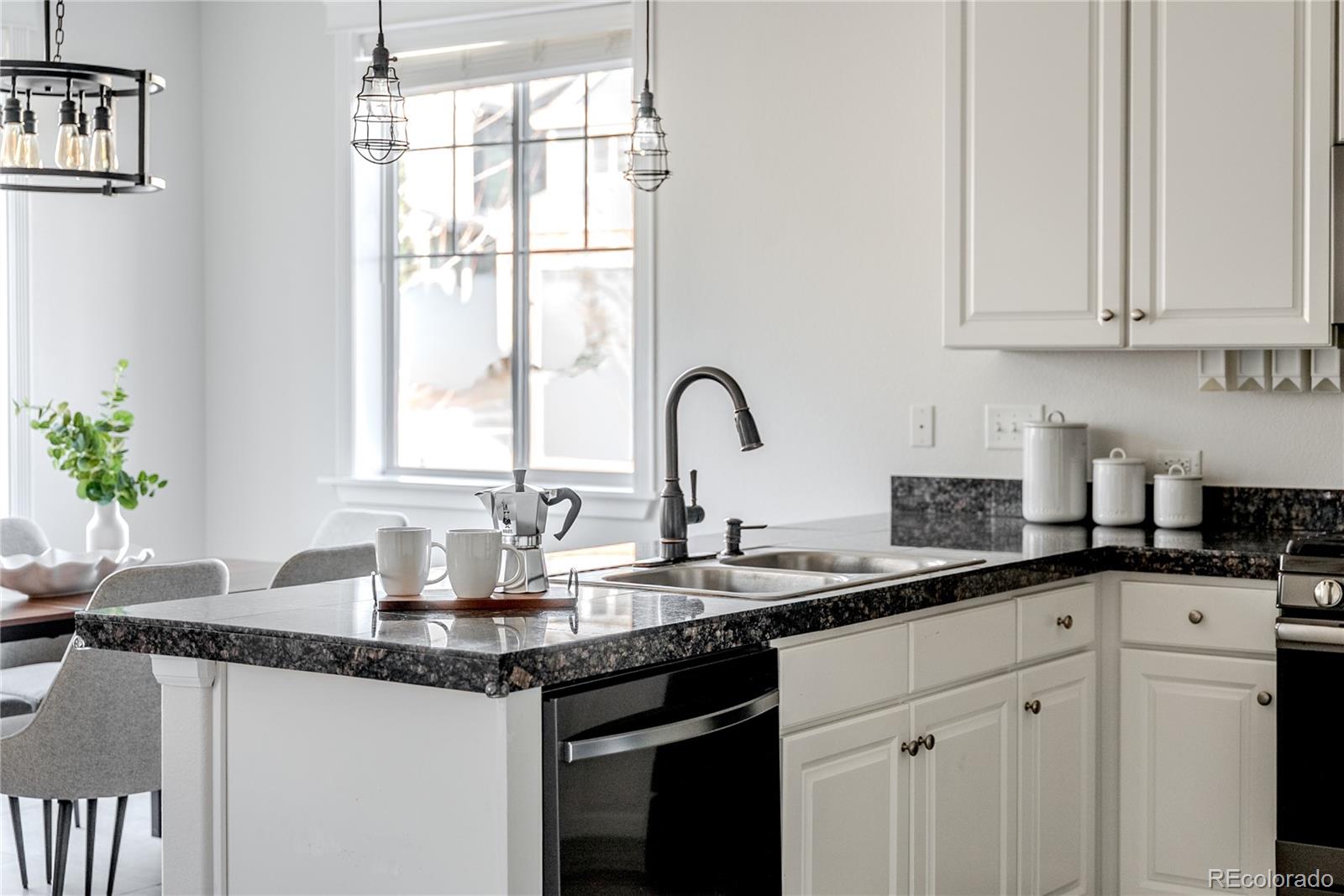 602 Mathews Way Erie, CO 80516 - Photo 10 of 50 a kitchen with granite countertop white cabinets and window
