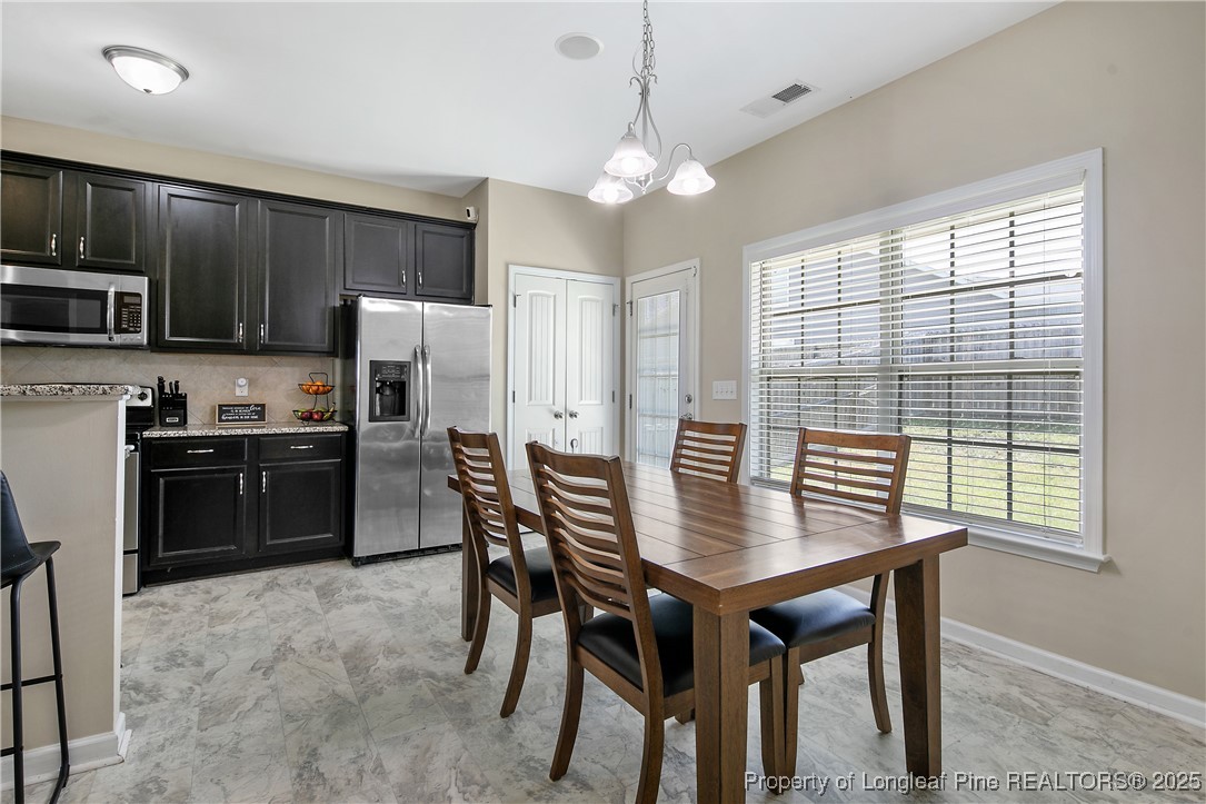 21 Bicentennial Way Cameron, NC 28326 - Photo 17 of 50 a kitchen with a refrigerator a stove a sink a dining table and chairs