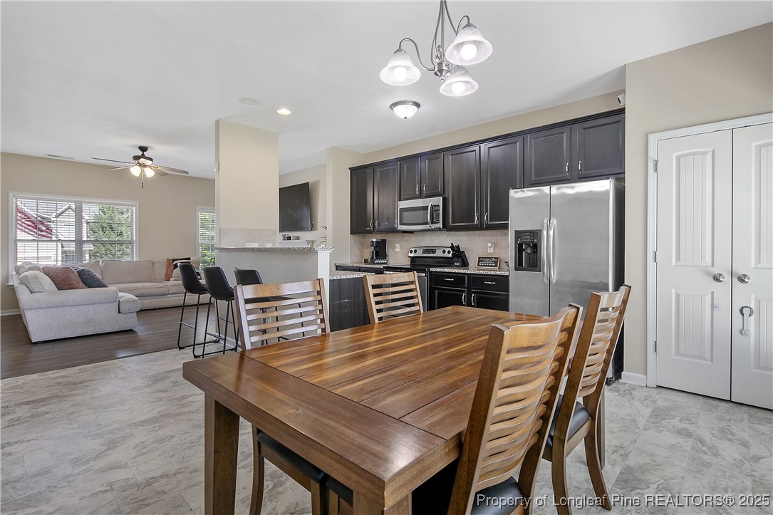 21 Bicentennial Way Cameron, NC 28326 - Photo 21 of 50 a kitchen with stainless steel appliances granite countertop a stove a refrigerator a kitchen island a dining table and chairs