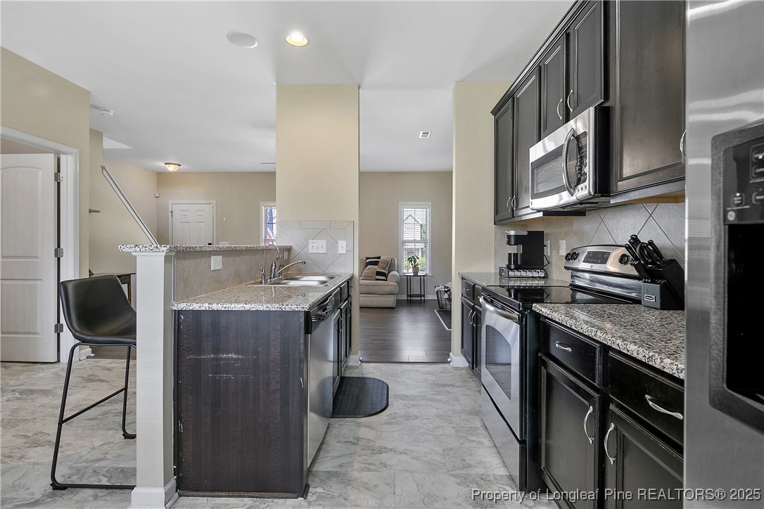 21 Bicentennial Way Cameron, NC 28326 - Photo 23 of 50 a kitchen with stainless steel appliances granite countertop a stove top oven a sink a counter space and cabinets