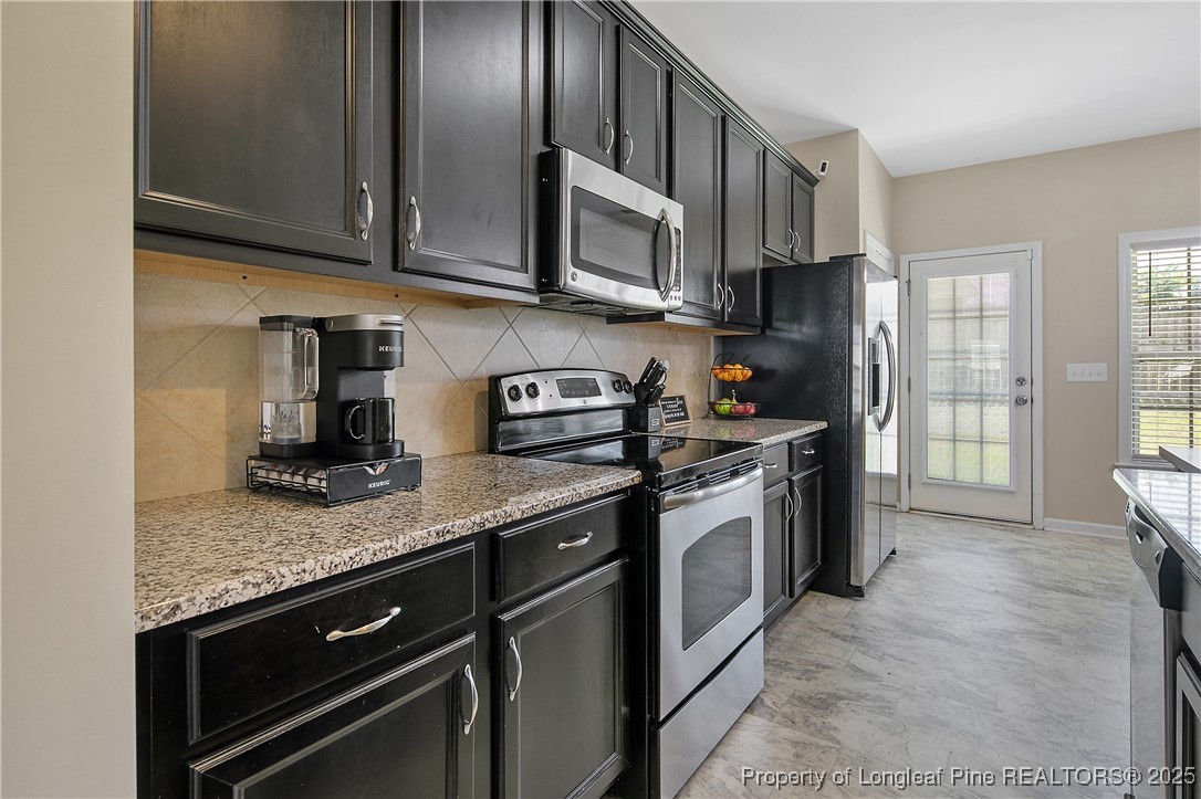 21 Bicentennial Way Cameron, NC 28326 - Photo 25 of 50 a kitchen with stainless steel appliances granite countertop a sink stove and microwave