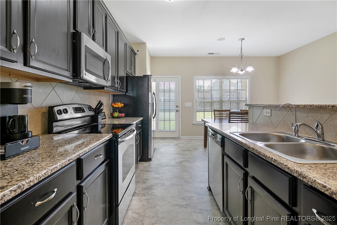 21 Bicentennial Way Cameron, NC 28326 - Photo 26 of 50 a kitchen with stainless steel appliances granite countertop a sink a stove and a refrigerator