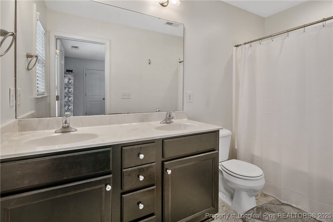 21 Bicentennial Way Cameron, NC 28326 - Photo 33 of 50 a bathroom with a granite countertop sink a toilet and a mirror