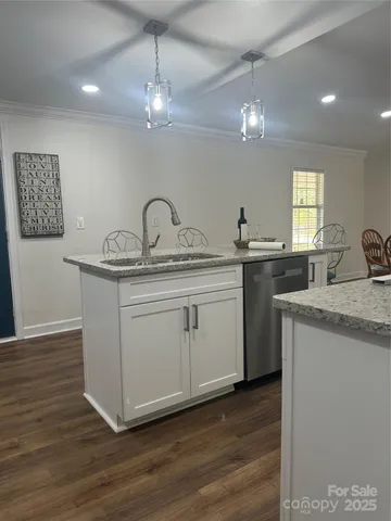 a kitchen with a sink cabinets and wooden floor