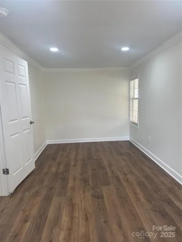 an empty room with wooden floor and window