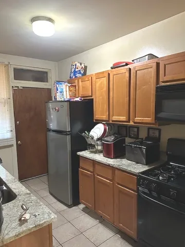 a kitchen with stainless steel appliances granite countertop a refrigerator a sink and a stove