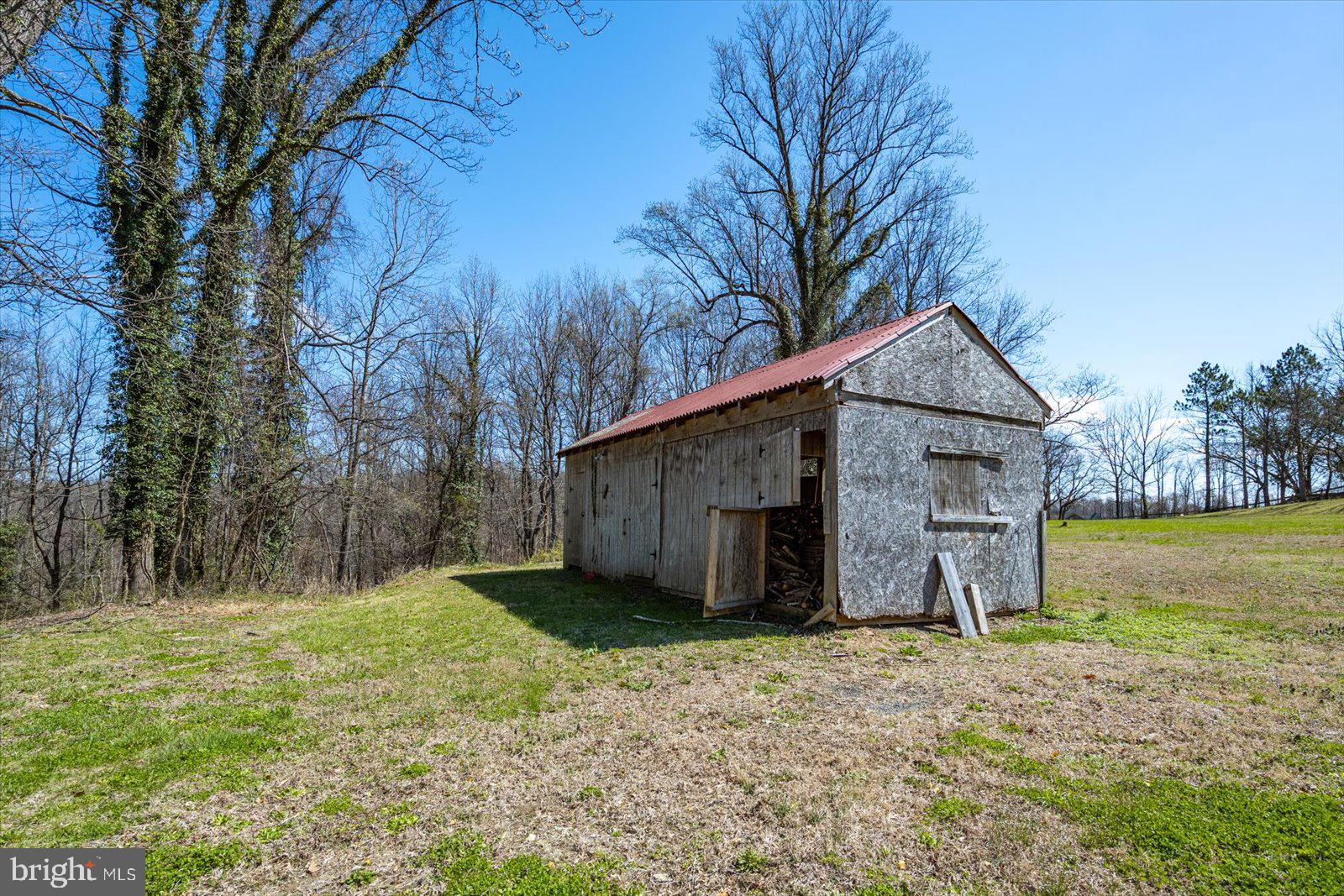 1118 Gum Bottom Road Crownsville, MD 21032 - Photo 42 of 52 Rustic wood shed in serene landscape.