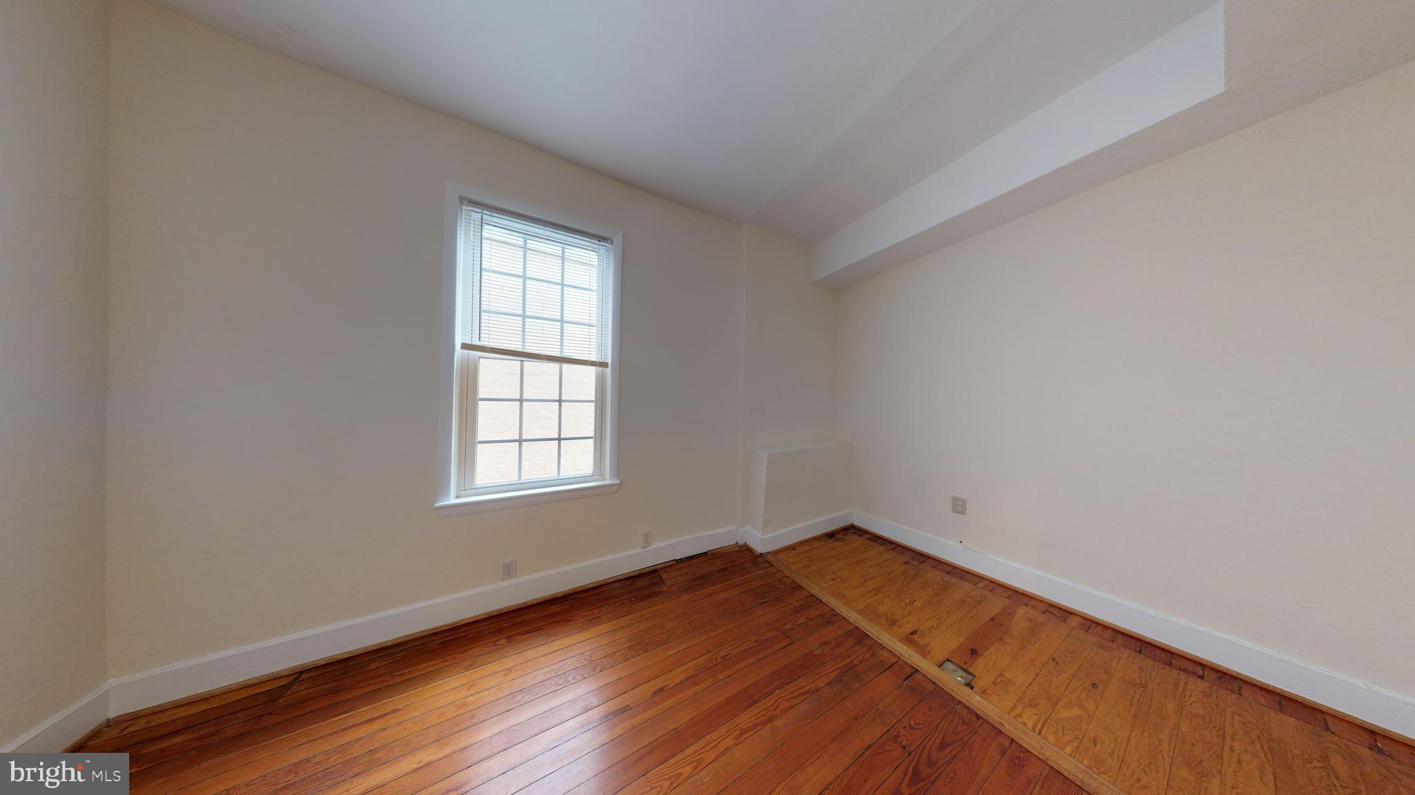 1307 22nd Street Northwest Washington, DC 20037 - Photo 13 of 46 an empty room with wooden floor and window