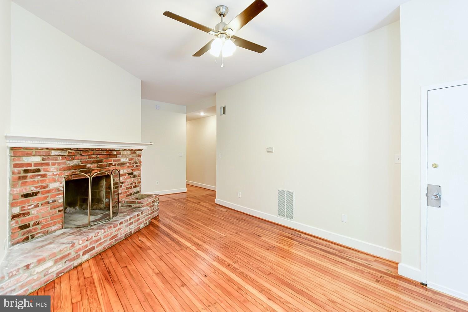 1307 22nd Street Northwest Washington, DC 20037 - Photo 18 of 46 a view of a livingroom with wooden floor a ceiling fan and a fireplace