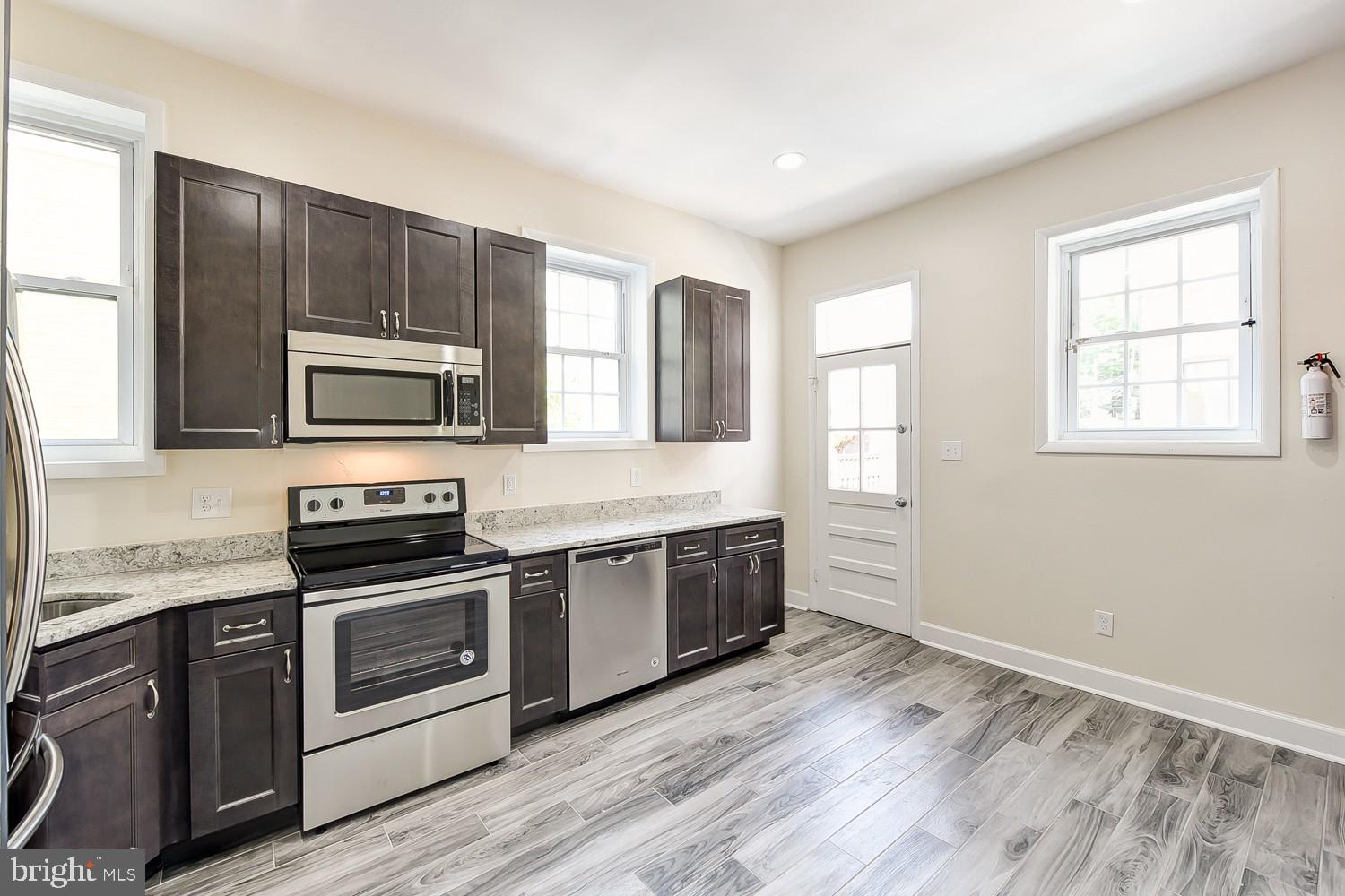 1307 22nd Street Northwest Washington, DC 20037 - Photo 21 of 46 a kitchen with stainless steel appliances granite countertop a stove a sink and a microwave