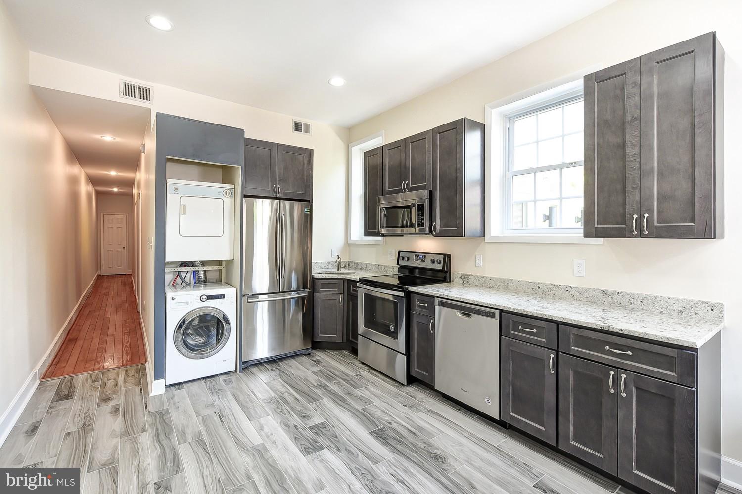 1307 22nd Street Northwest Washington, DC 20037 - Photo 22 of 46 a kitchen with stainless steel appliances granite countertop a refrigerator a sink dishwasher a stove and white countertops with wooden floor