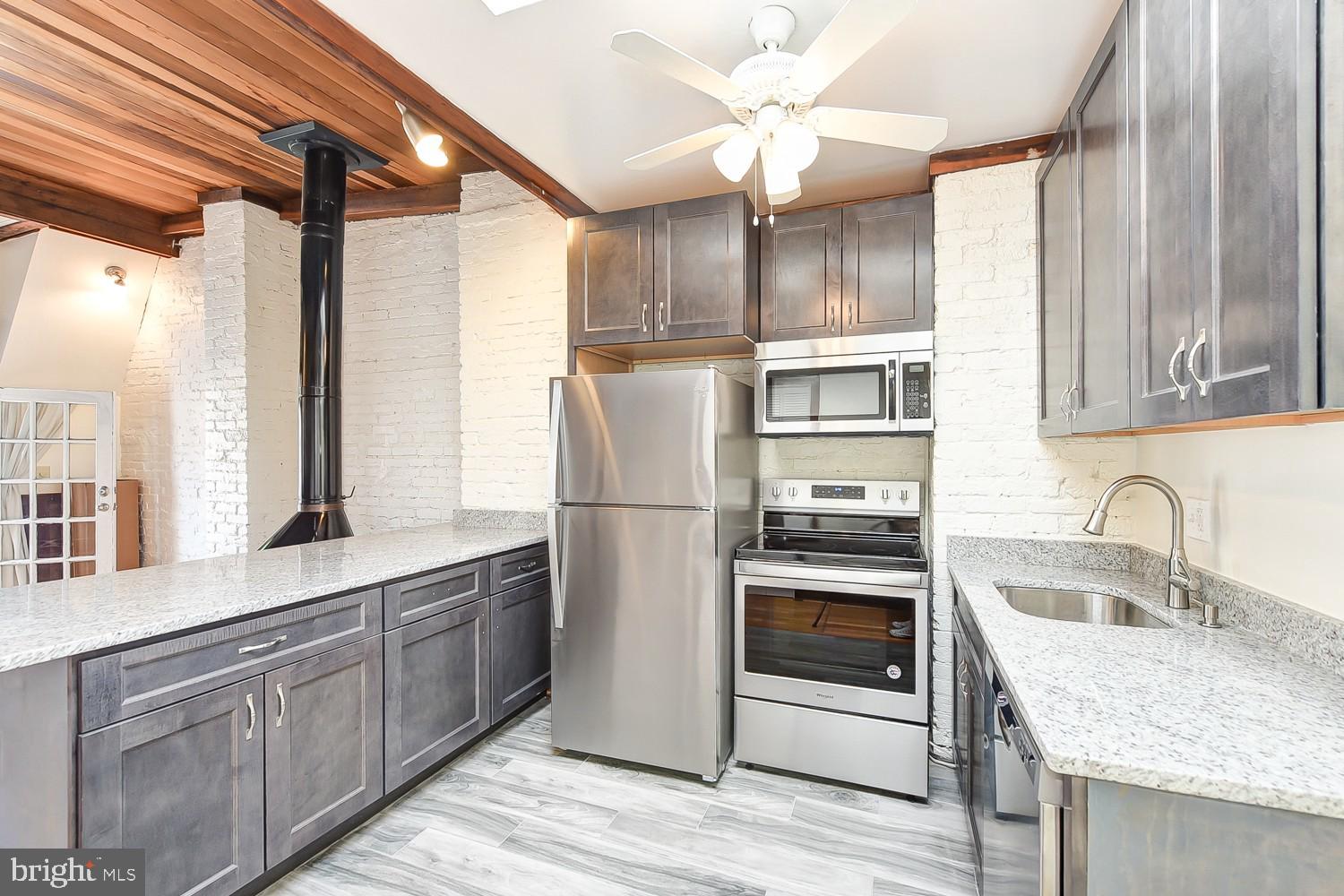 1307 22nd Street Northwest Washington, DC 20037 - Photo 30 of 46 a kitchen with stainless steel appliances granite countertop a sink and a refrigerator