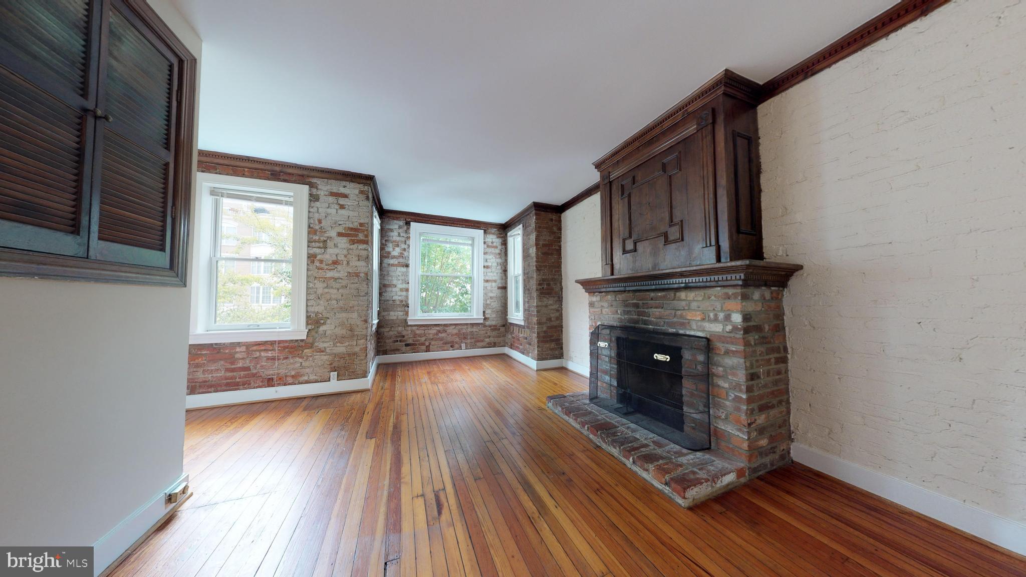 1307 22nd Street Northwest Washington, DC 20037 - Photo 3 of 46 a view of an empty room with wooden floor fireplace and a window
