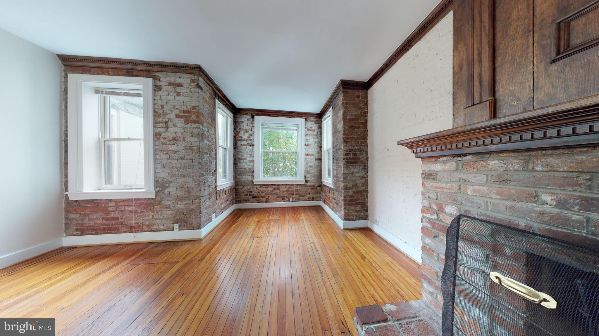 1307 22nd Street Northwest Washington, DC 20037 - Photo 4 of 46 a view of empty room with wooden floor and fireplace