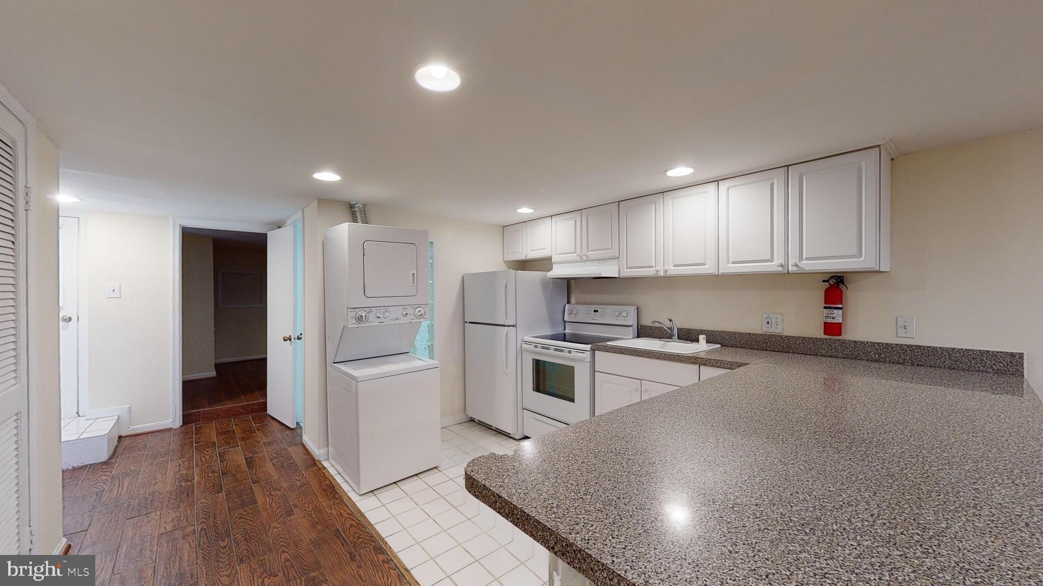 1307 22nd Street Northwest Washington, DC 20037 - Photo 41 of 46 a kitchen with a refrigerator and white cabinets