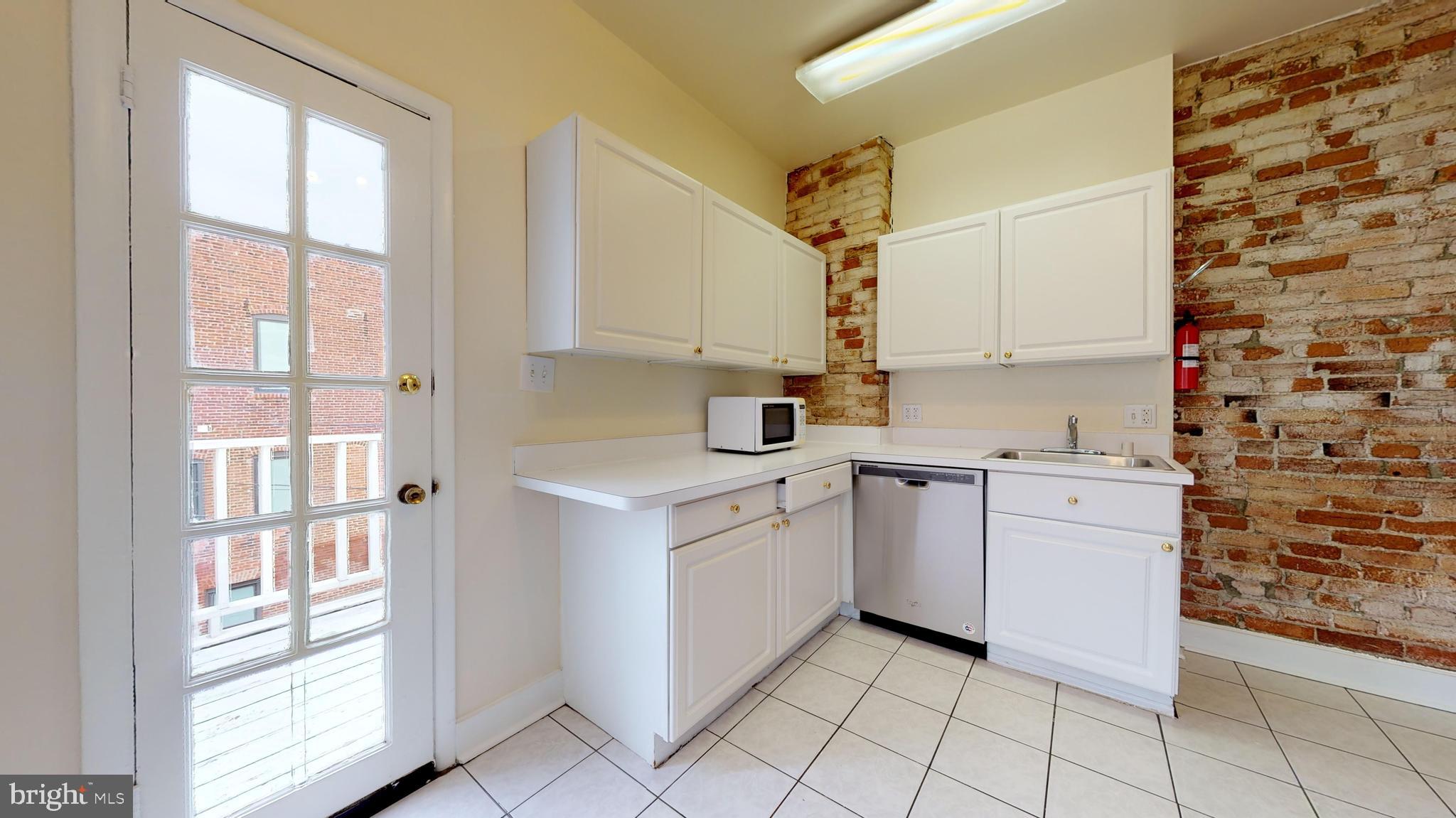 1307 22nd Street Northwest Washington, DC 20037 - Photo 9 of 46 a kitchen with a stove a sink and a window