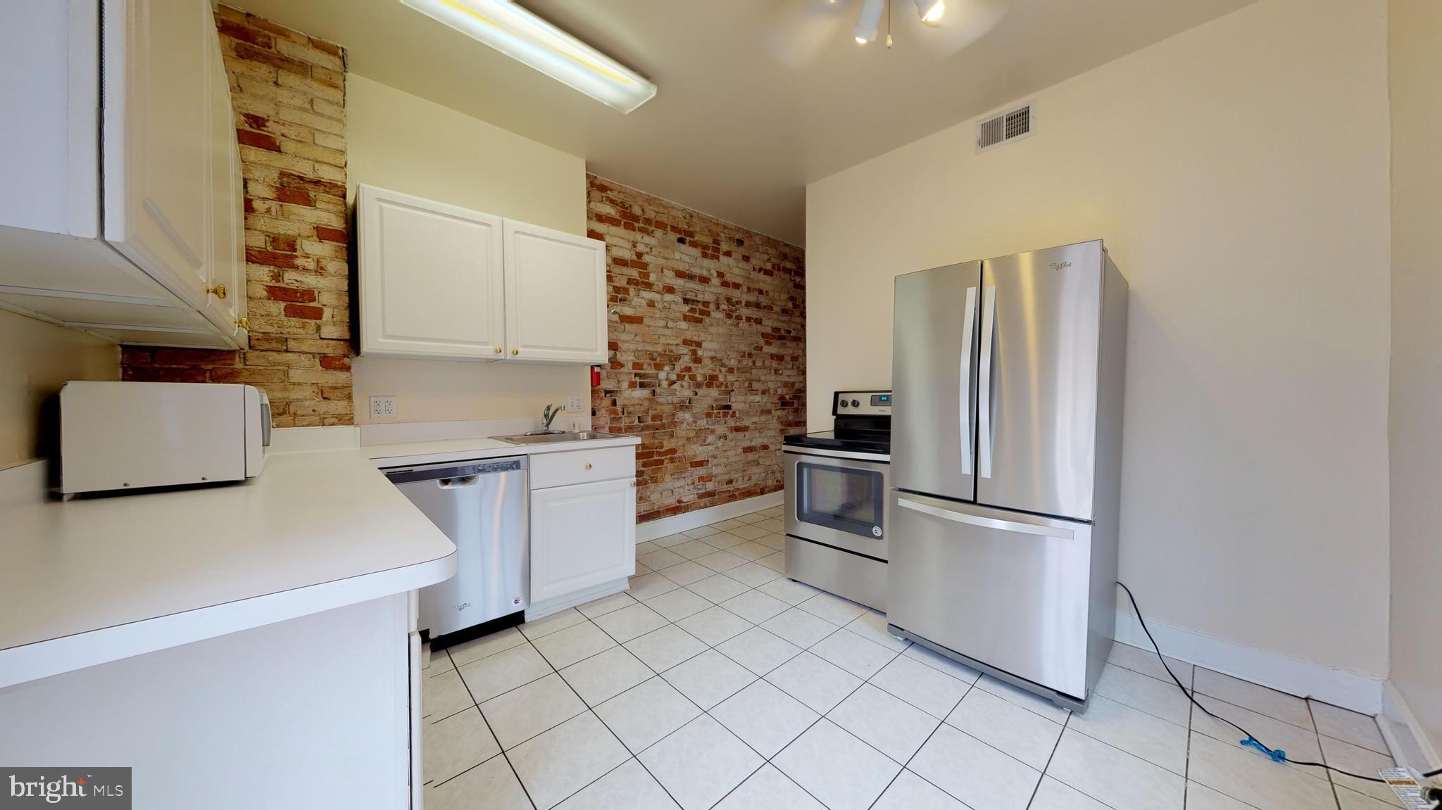 1307 22nd Street Northwest Washington, DC 20037 - Photo 10 of 46 a kitchen with a refrigerator and a stove top oven