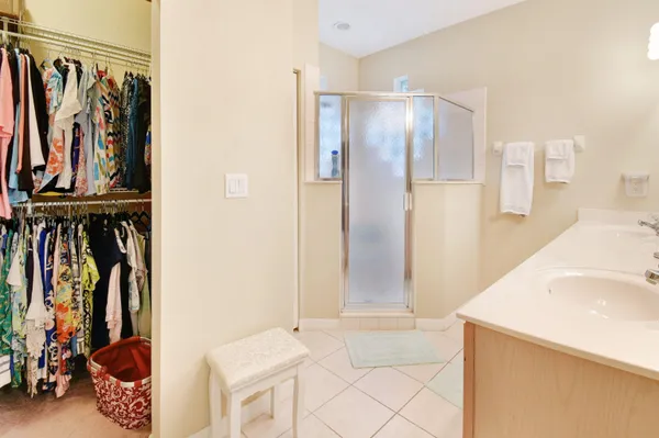 a view of walk in closet with clothes and shoes