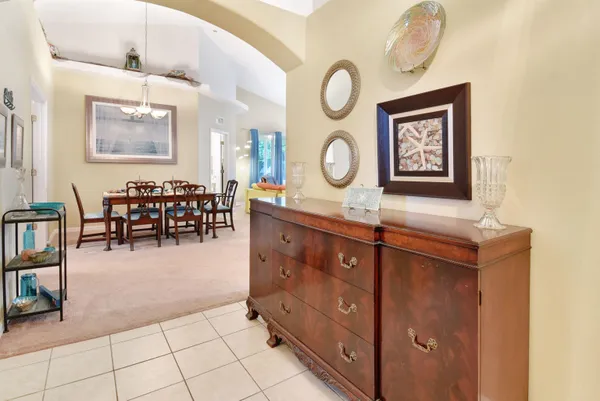 a hallway with mirror on the wall and a table