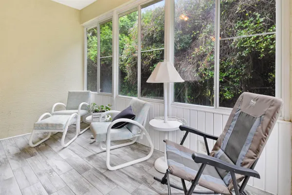 a view of a patio with a dining table and chairs with wooden floor