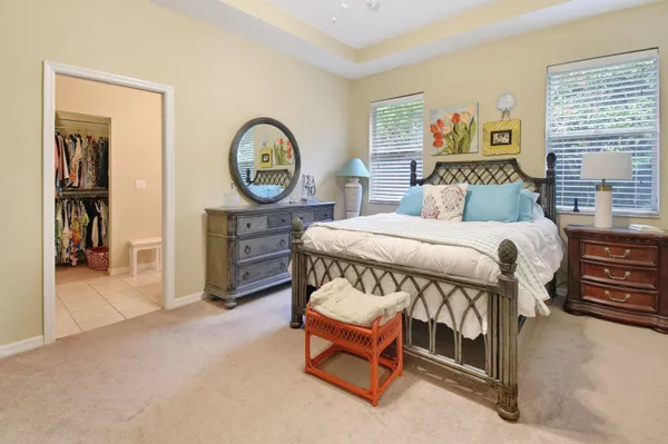 a bedroom with a bed a mirror and a window