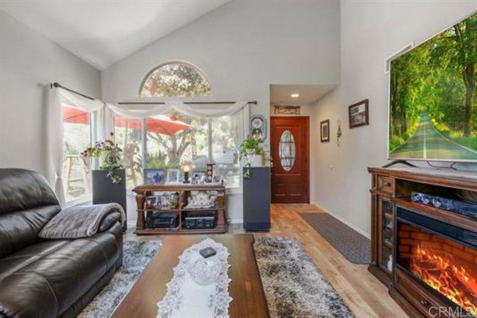 2277 Dunstan Street Oceanside, CA 92054 - Photo 4 of 36 a living room with furniture a fireplace and a floor to ceiling window