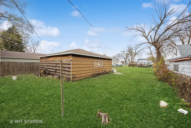 a backyard of a house with plants and large tree