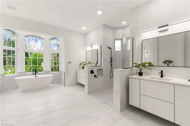 a large white room with mirror on the shower and sink