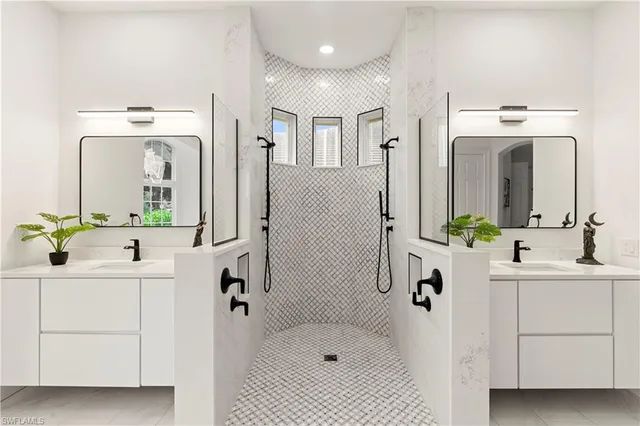 a bathroom with a double vanity sink mirror and bathtub