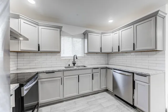a kitchen with a sink cabinets and window