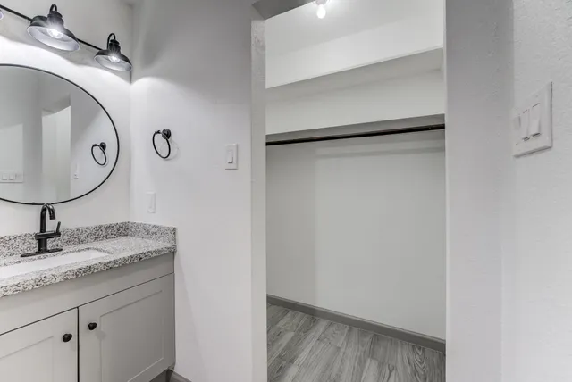 a bathroom with a granite countertop sink and a mirror