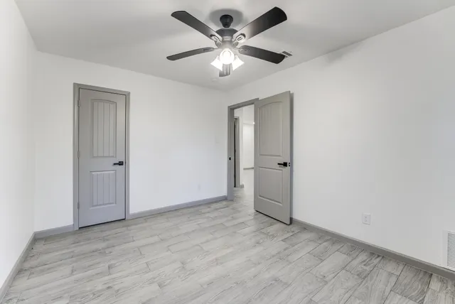an empty room with fan and a ceiling fan