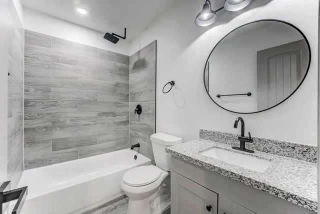 a bathroom with a sink a toilet and a mirror