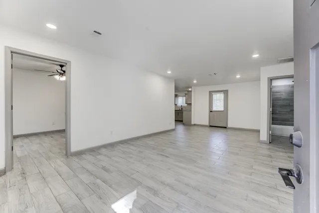 an empty room with wooden floor and windows