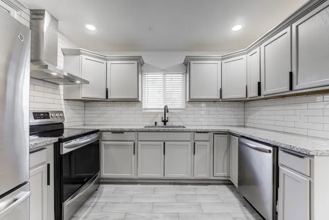a kitchen with stainless steel appliances granite countertop a sink stove and cabinets